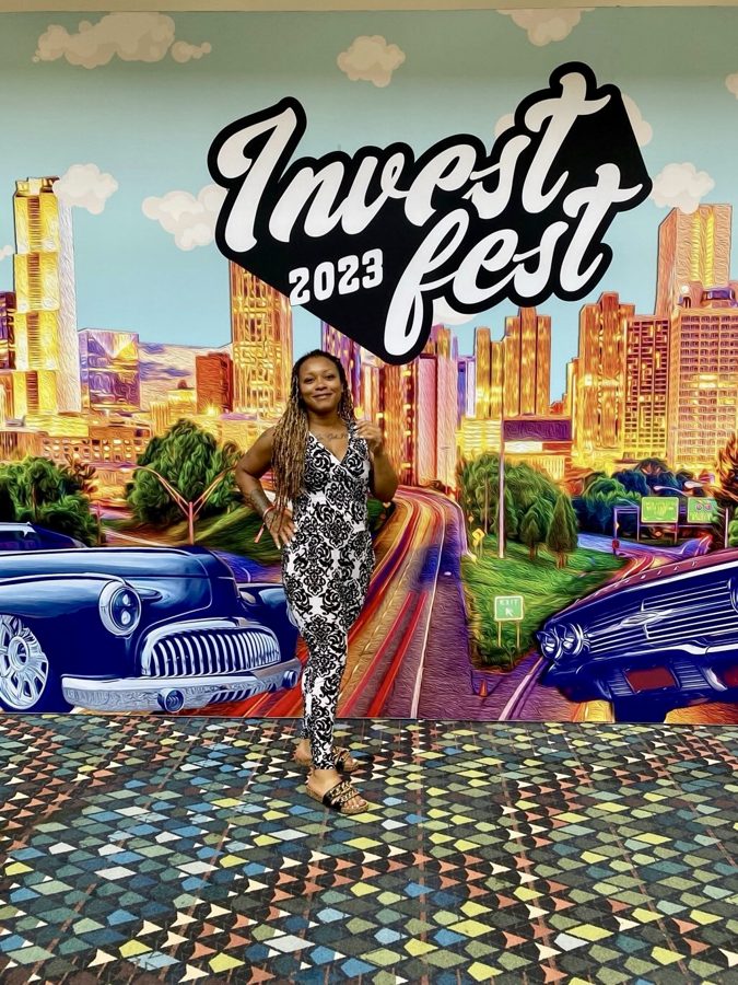 Erica at InvestFest 2023 in front of the event mural